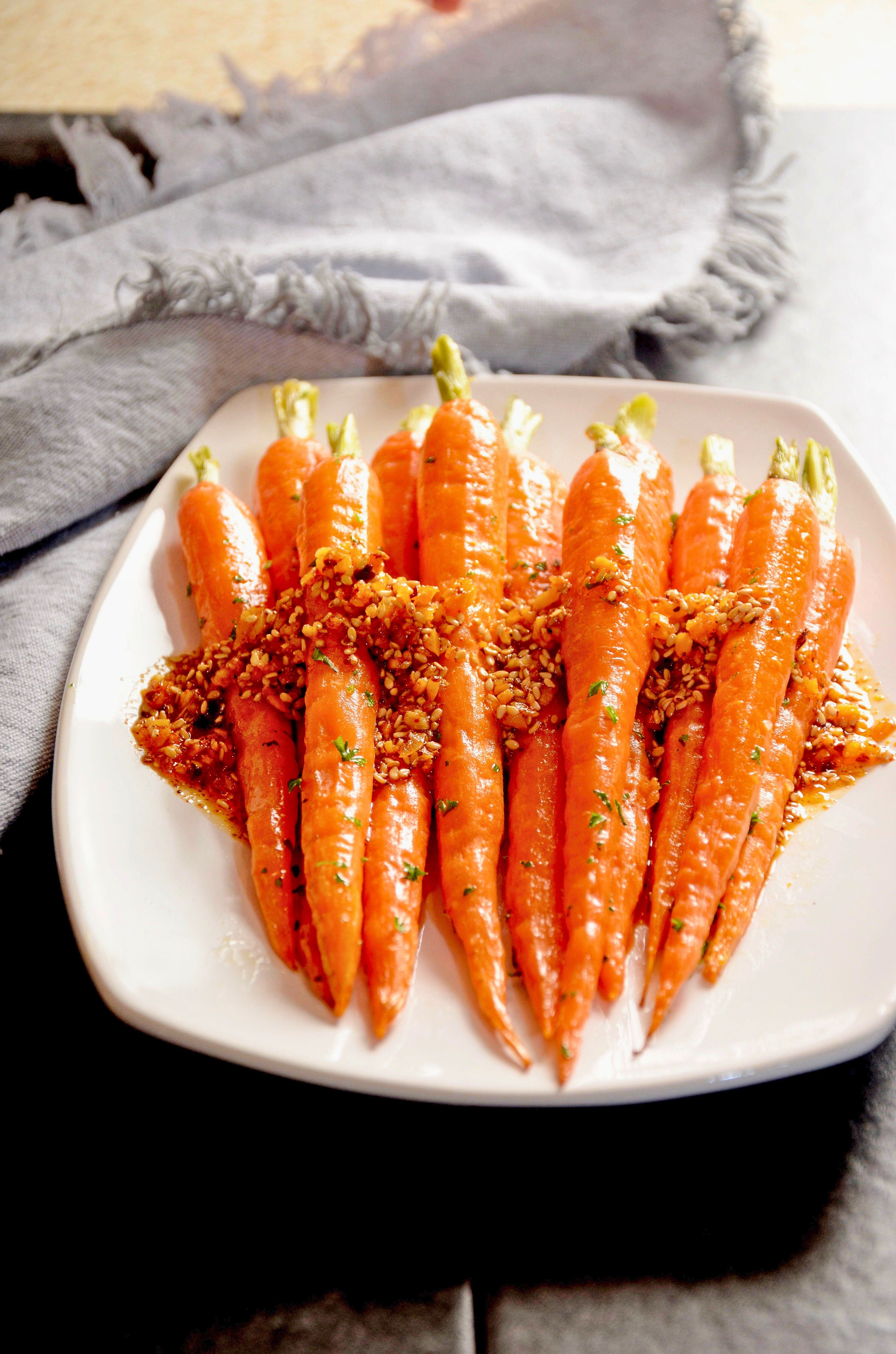 Ruby Crunch chili crisp generously drizzled over roasted whole carrots on a platter