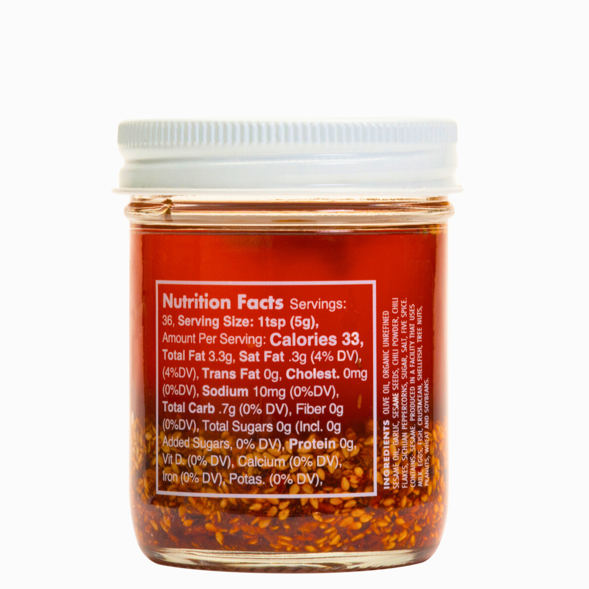 Nutrition facts & clean-label ingredients on a Ruby Crunch olive oil chili crisp condiment jar, showing the ruby hued oil & crispy bits.