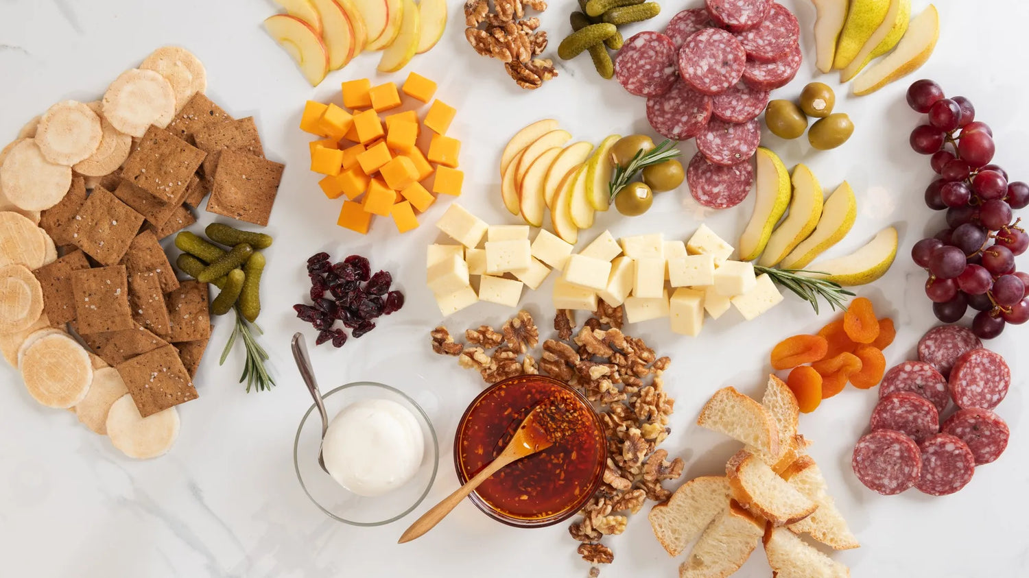 A sprawling arrangement of Ruby Crunch chili crisp, cheeses, meats, olives, nuts, pickles, crackers, bread, and fruit