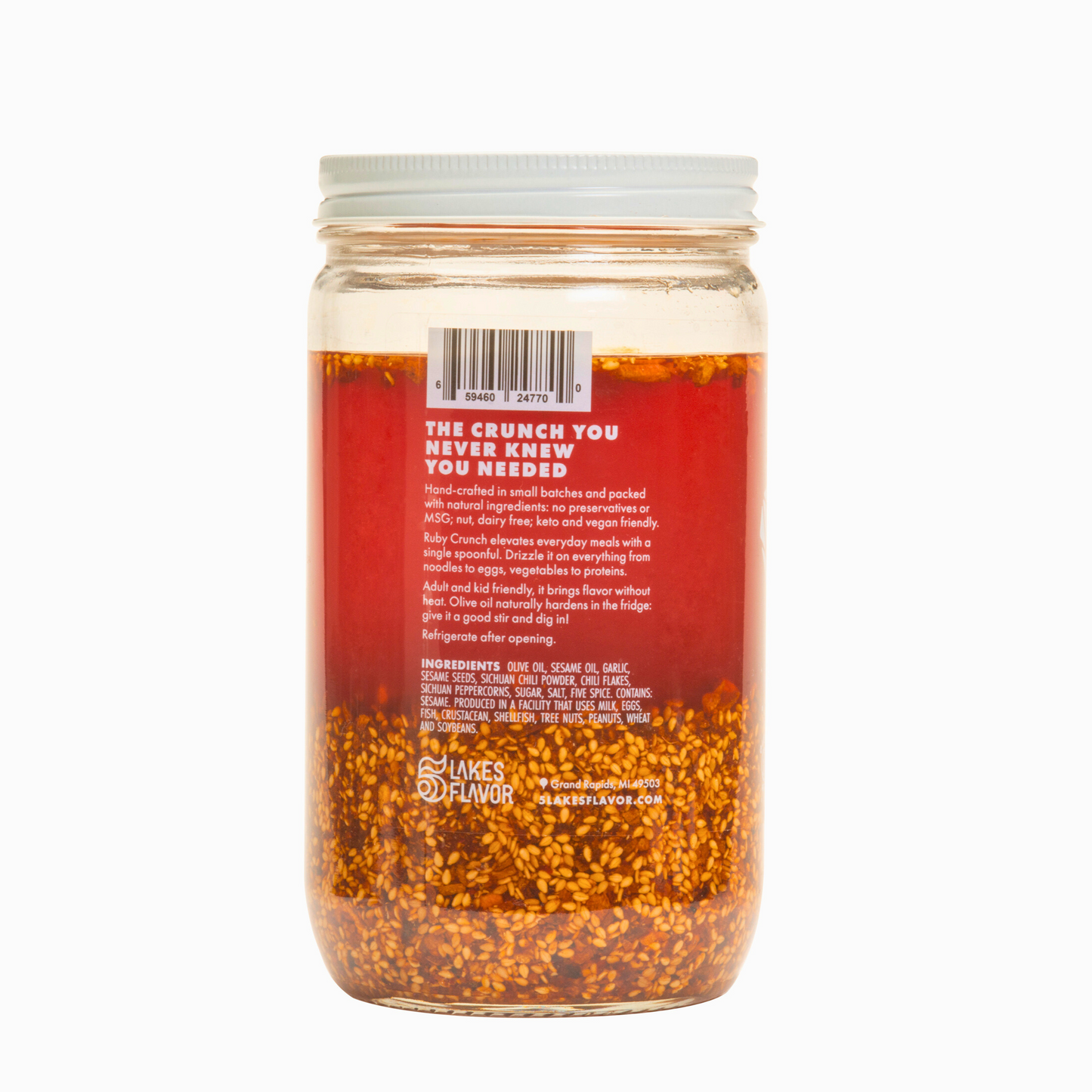 Side view of 32oz Ruby Crunch olive oil chili crisp hospitality jar, highlighting product description alongside ruby hued oil & crispy bits.